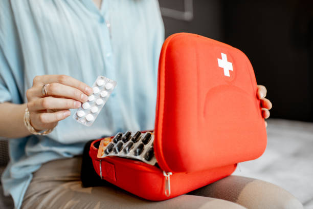 Woman taking pills from the first aid kit, close-up with no face